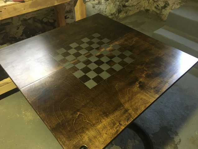 Here is the top of the table. Decided to add a chessboard pattern, mostly as my eldest loves chess. Particularly as he’s better than me at it. Done by masking off the top using wide painters tape, drawing the pattern, and then cutting away half the spaces. I then hit it with a silver spray paint before varnishing the whole surface.