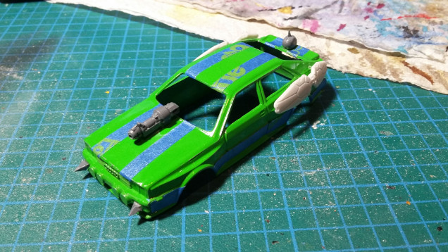 I separated the car to make painting easier. Then I added some bits from my bits box. I also masked off the areas I wanted to keep the original green.