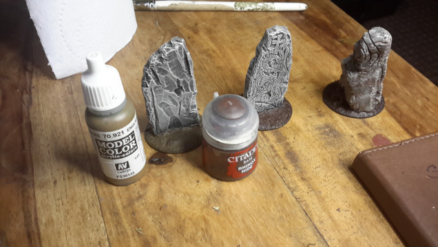 I have some standing stones by Fenris Miniatures that were painted at different times, the viking stones were a lot darker than the spiral stone so I progressively dry brushed,  Vallejo Khaki Grey, GW Ushbati Bone and finally a light dry brush of white. I then proceeded to the stones and Vachel's bases, I started with a base coat of GW Rhinox Hide, followed by dry brushes of the paint illustrated in this and the following photo.