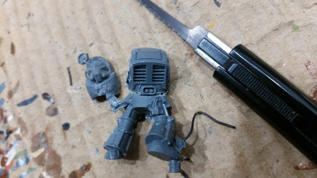 I cut the models torso from the legs, again using the saw. I found out that it works best to cut below the oval detail on the back. Also the front part of the model came loose during this step.