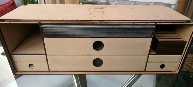 The front section is removed revealing space for 5-6 shadespire boards, two large trays for miniatures (potentially 4+ warbands) two card and dice draws and 2 token draws and at both sides there is an additional storage hole for extra unused cards etc...