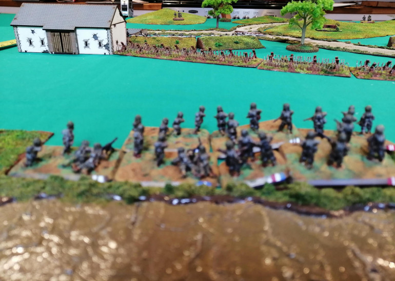 Assault Platoon A looks at the barbed wire the defending Germans dug in behind