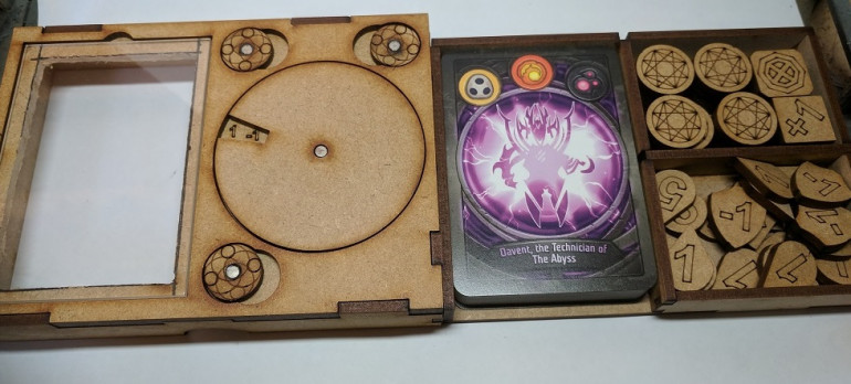 The box slides apart giving you a compartment for your deck and two side compartments one for your Aember and the other for your assorted game tokens.
