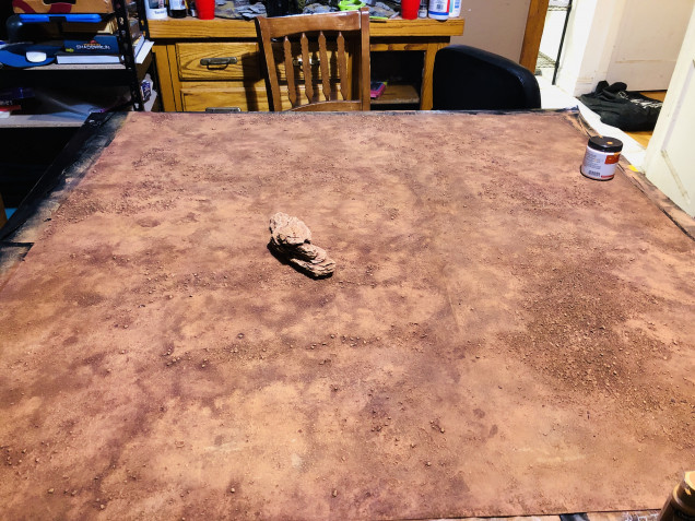 The base of the table is a mat made from a canvas drop cloth coated with acrylic caulk, textured with sand and painted in with the colors chosen in the last post, when this was dry it was washed with a homemade wash a mixture dark brown, black and red. This was was applied in sections and then “sponged” off with paper towel to give the variations in colors and the mottled look it has 