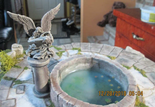 GW angel with amphora made from Milliput, a paper clip, and a GW elf bit. Note the leaves in the water. They were made with a Green Stuff leaf cutter and painted paper.