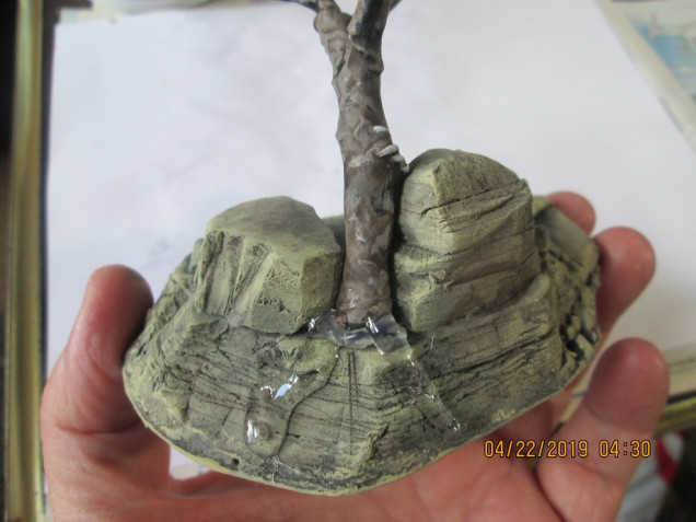 I stuck the tree into the base with a glue gun and added some glue as 'roots,' to help keep it in place. It doesn't look much like roots at this stage, but I'll hide this ham fisted effort with paint and weeds.