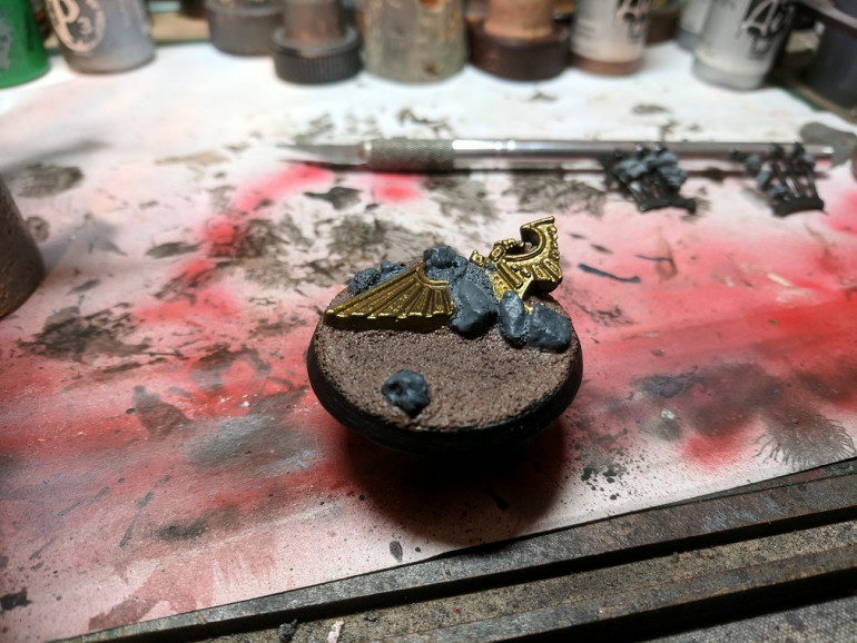 Gave the base a very basic undercoat of black followed by an earthy brown for the soil, blighted gold (P3) for the eagle and a dark grey for the stones.