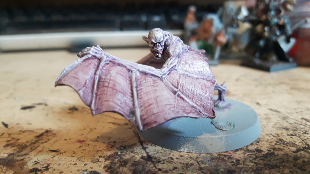 I've missed a few steps out, I got carried away and forgot to take pictures. So far I've washed the body with Druchii violet and the wing membranes with carroburg crimson. Once that was dry I drybrushed the whole thing with rakarth flesh (heavier on the body and lighter on wings). I then put a final highlight by drybrushing the body lightly with pallid Wych flesh. I also painted the tongue, claws and teeth.