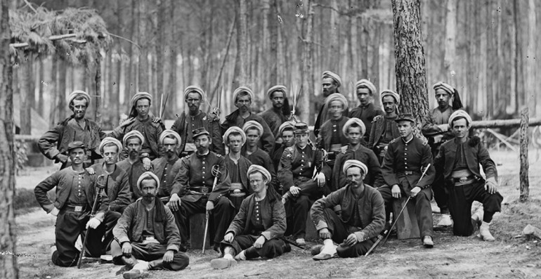 The NCO's of the 122nd Galland with the Regimental Colonel (Left), Battalion Lieutenant Colonel (Centre) and Battalion Major (Right). All the Men are in Fatigues which for the NCO's is a Turban without a Helmet, Less Baggy Pants to Assist with Manual Labour and a Non-Armoured Jacket with Cuffs (Near the Wrists) In Pink. Officers Wear a Cap but Otherwise Maintain the Uniform. On the Far Left is the Colonel's Son, Serving as Ensign. Ensign's Wear the Uniform's of the Men but Replace the Turban with a Cap in Fatigue Dress.