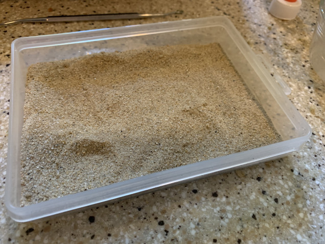 A tub of sand. In this case from Games Workshop. 