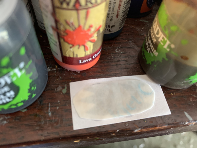 Use a small brush and carefully add water to the paperback of the transfer. Keep a paper towel handy and try not to get water on the white paper the transfer is being mounted to. If you do, just blot it up.