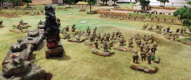 The 1st Canadian Armoured Brigade continue their advance past the burning wreck of the lead tank