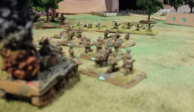 Green Platoon advance past the wreck of a burning Sherman