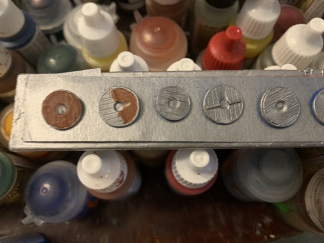 A mix of Oathmark and Gripping Beast plastic shields primed with Army Painter Plate Mail Metal primer. The wooden elements are being painted Army Painter Fur Brown. This will require at least two thin coats of the Fur Brown to get good coverage. 