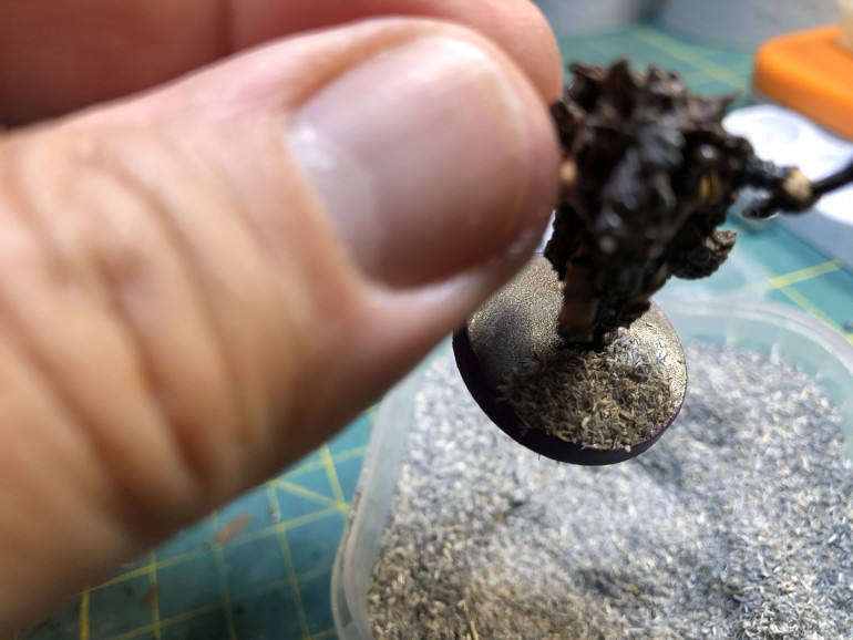 Then remove the miniature from the container, press gently on the basing material adhering to the base and finally tap the base over they container to minimize waste.