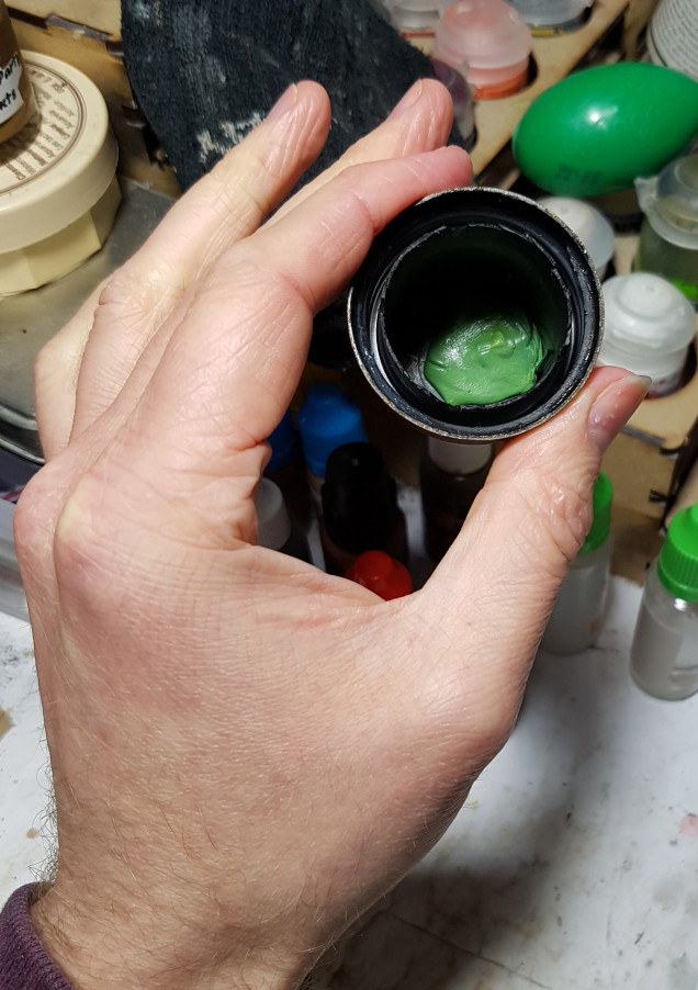 Mix up two lumps of green stuff.  You want a little between the paperclip and the cap, and the bigger piece over all of the paperclip.  This serves two purposes.  To hold it in place and to block the hole so it is waterproof, to avoid leakage later.  You could always leave it here.