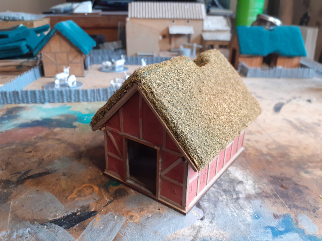 This is the Cottage. Here I have completed all the beams and then to naturalise the look of the plaster areas I have carefully applied Games Workshop Martian Earth  which provides a nice texture which will hopefully take dry brushing really well. You can also see that I have capped the edges of the roof beneath the thatch with my wooden beam material.