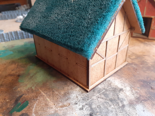 This is the barn, here you can see I have started to add the wooden beams. The new roof coverings are brillo pads, as seen at the Sarissa stand, easy to attach (super glue) and then trim down sharp corners and edges with nail scissors. 