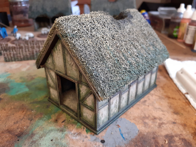 The finished cottage. The roofs were dry brushed in In AP khaki grey and skeleton bone, I then added some of the green wash at the bottom edge feathering upwards. Finally I heavily drybrushed black around the chimney openings.e