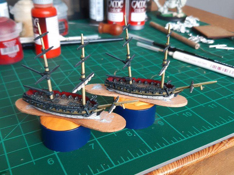 Pair of brigs freshly painted, awaiting sails, ratlines and rigging.