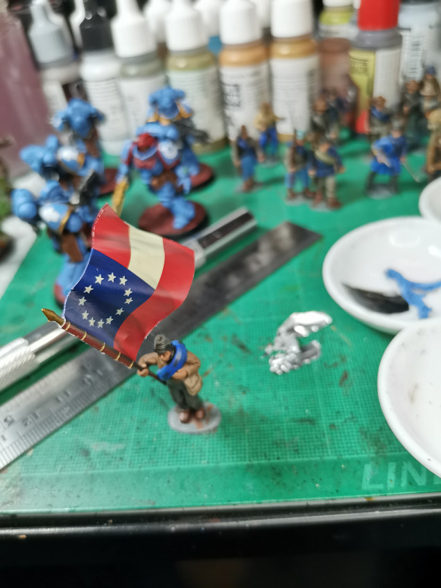 Flag was trimmed, folded and then watered down PVA was applied. A small square of tinfoil is placed in the mddle of the two flag halves; this gives enough structural integrity to bend the flag. Do not bend too far or will leave white stretch marks. 