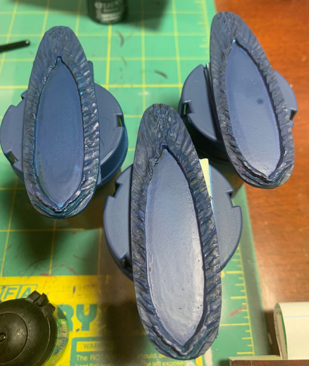 Go back over the dried base with an Overbrush (a wet Drybrush) of Kantor Blue. Be a little bit heavier with it but leave the green wash in the recesses.