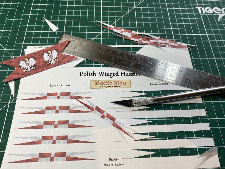 To cut out paper flags I find a sharp blade and a metal ruler are the easiest things to use.