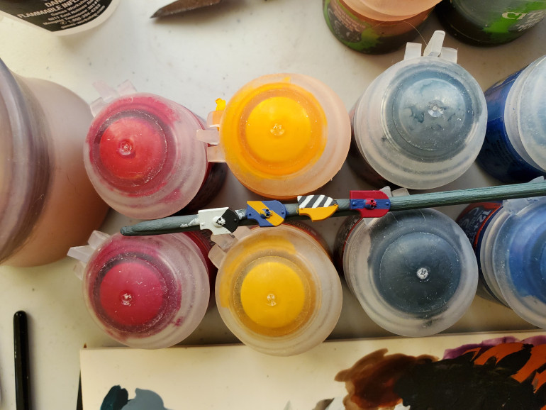 Next came the heraldic bit. These probably all have technical names, but I only know a few of them. I decided not to try adding in symbols just to not confuse the army badges, but the top (left) one is 'impaled(?)' with black, the next has a yellow bend(?) next has a halved pattern with the white stripes not being perfect, but good enough and the last one almost getting white outlines on the blue bar to make it look a little Norwegian. Thin paints and steady hands work well here. Paint the outlines then fill in the shapes and use markers on the shields such as the skulls or the rivets to guide your lines.