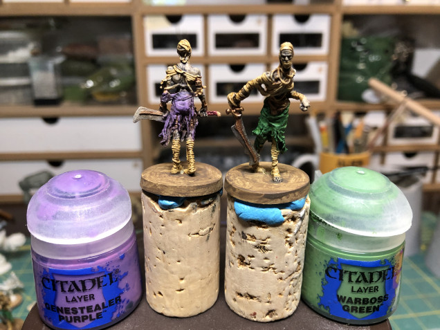 Highlighting the clothes with a drybrush/small brush (for smaller areas too close to previously detailed areas) highlight using Genestealer Purple and Warboss Green