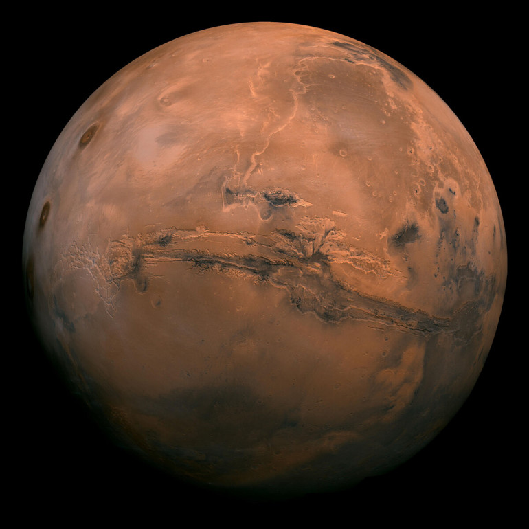 The Red Planet...that is actually sort of brown-ish. The massive scar you can see here is an ancient canyon called Valles Marineris that shows signs of once carrying water across the surface.