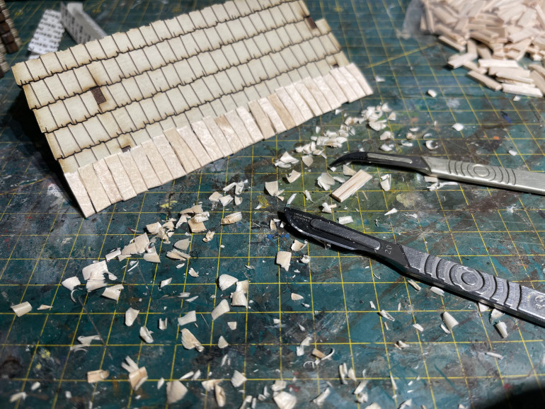 cutting down the top of the first layer of shingles