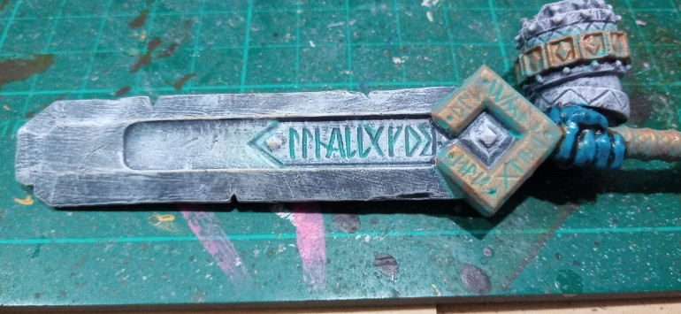 I imagine when he first used it the sword was nice and shiny but after a few centuries left exposed to the elements the blade is in need of a bit of a polish. The Runes in the Blade also got a light layer to make them look a little magical