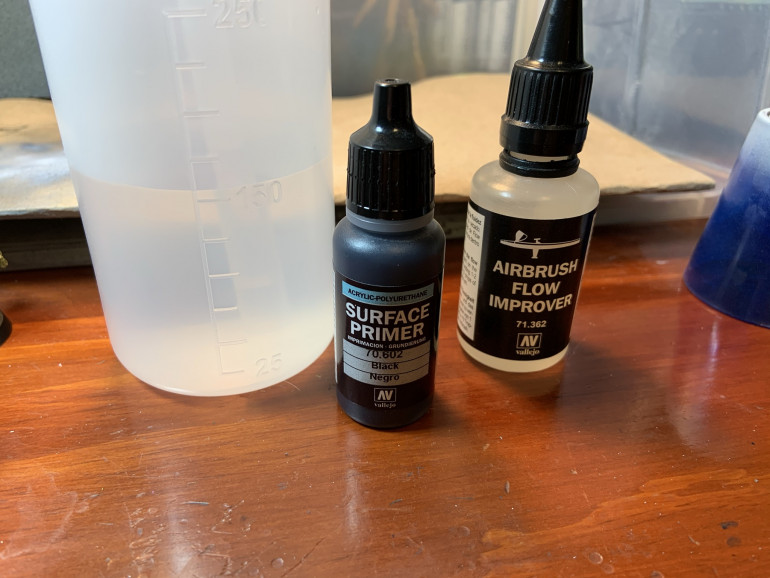 I start with Vallejo Surface primer (70.602 Black)...about 20 drops, mixed with 8 drops of Vallejo Airbrush Flow Improver and a little water. The flow improver helps reduce fuzziness on the model (as it extends drying time slightly) and reduces clogs a lot.