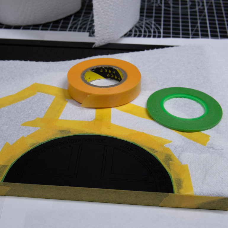 I masked out the logo area using model masking tape. Paint was fresh and I don't want it tearing when taking the tape off. this green tape was excellently flexible making it easier to do the curve. I then used kitchen towel to avoid overspray.