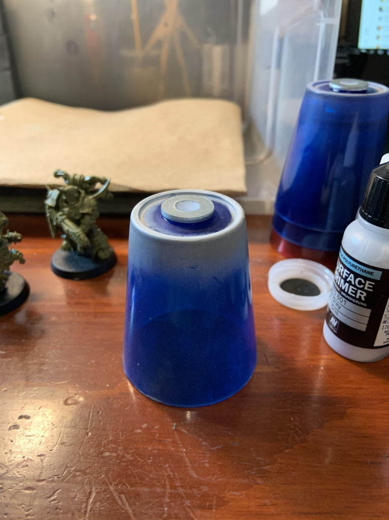 These are plastic shot glasses I purchased at Walmart for $0.20 a piece. I've super glued a washer to the bottom, so they make neat painting handles that I can easily swap magnetized models with (and I don't have to mess up my nice Citadel handles with overspray). The shot glasses also make it easy to dump paint/water/cleaner in when changing colors.