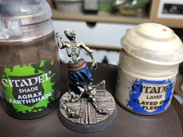 Apply a coat of GW Agrax Earthshade to the chains (to dull the shine and make them appear dusty and rusty-ish) as well as to the belt and rags. Drybrush the skeleton with GW Ushabti Bones on the surfaces exposed to zenithal light.