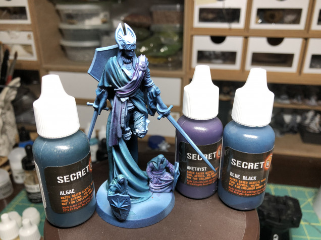 Using Secret Weapon Algae, Amethyst and Blue Black washes (which are more like glazes), I applied three different tints to the virtue cloak, pants and sash.