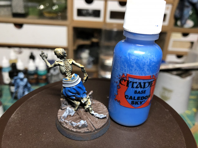 As the base and skeleton will have rather warm tones, I chose to color the ragged clothes blue, using GW Caledor Sky.