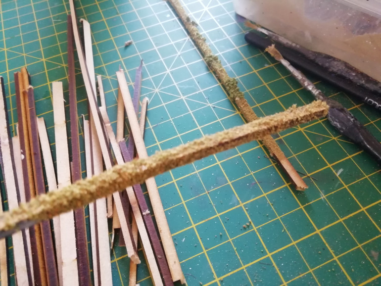 I was wondering how to make tiny hedges. I got some MDF left overs from old kits and simply dipped then in paint and flock