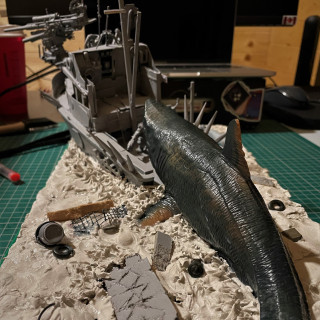 Adding the boat, orks, debris and fish to the diorama board along with half a brick of clay!