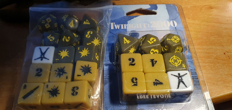 These engraved custom dice are designed specifically for the fourth edition of the Twilight: 2000 roleplaying game. The set includes:  Four base dice – one each of D6, D8, D10 and D12. Four D6 ammo dice. One D6 hit location die. (left dice from the box, right the extra dice pack)