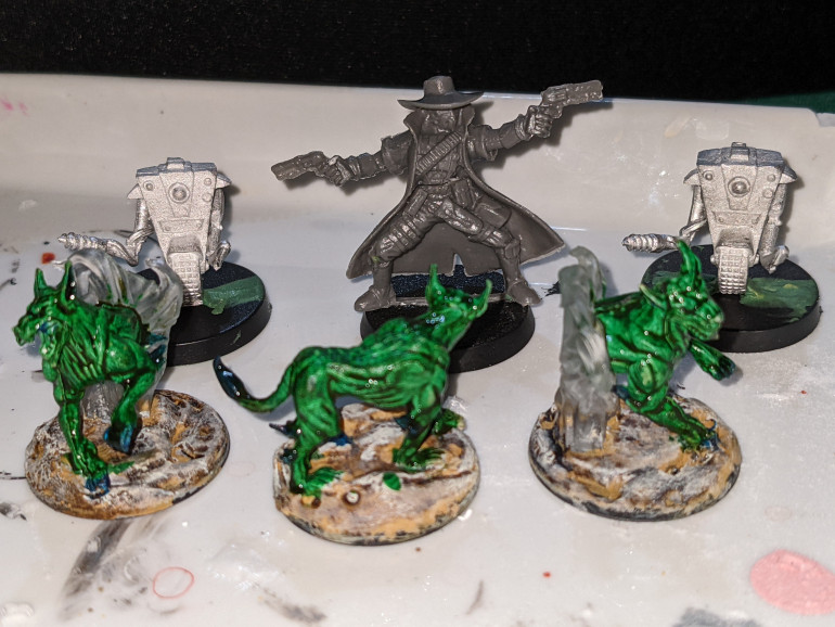 A little assembly tonight, putting a Texico MERCS cowboy on a base, and assembled my two serv-bots, one for a repairbot, the other because I have a friend at Gearbox with a birthday coming up. (Though I feel this is legally distinct one wheeled bot, not CL4P-TP.) Also, layer of military shader green on the dogs. We'll see how it looks tomorrow.