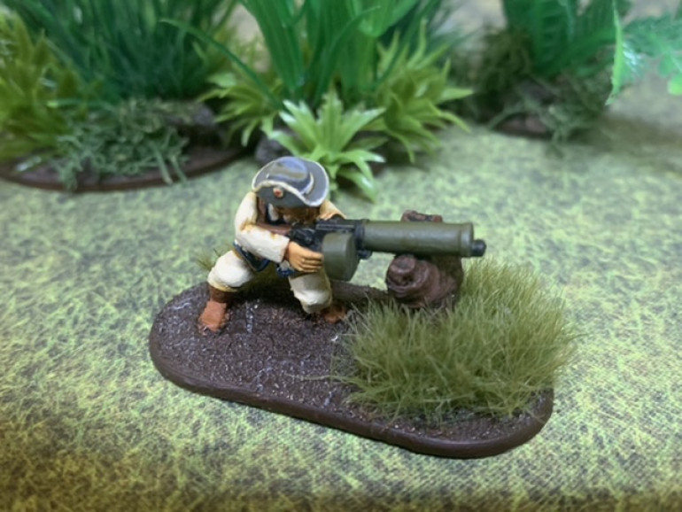 The “light” machine gunner from Pulp Figures. The mini as equipped had a lighter tripod, so I just eliminated and had the gunner brace himself on a log to represent it as an improvised field modification. 