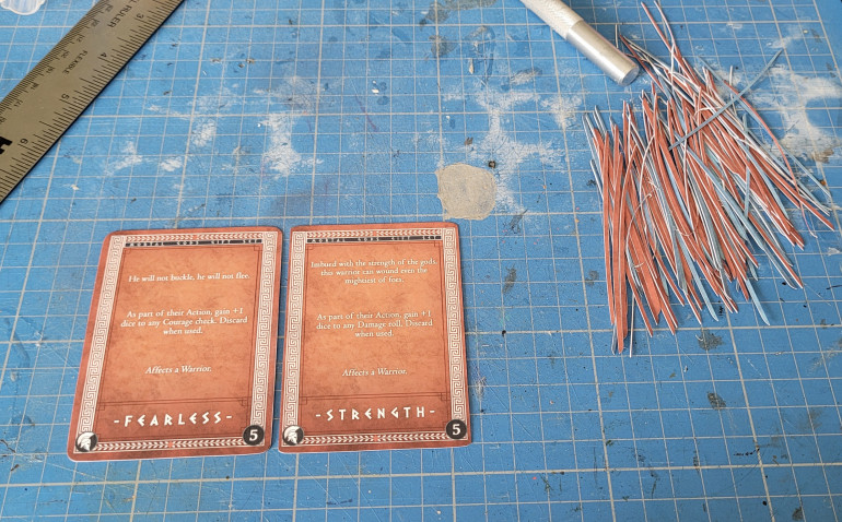 Metal ruler and a mm or two off each long side so that the cards will remain mostly centred 
