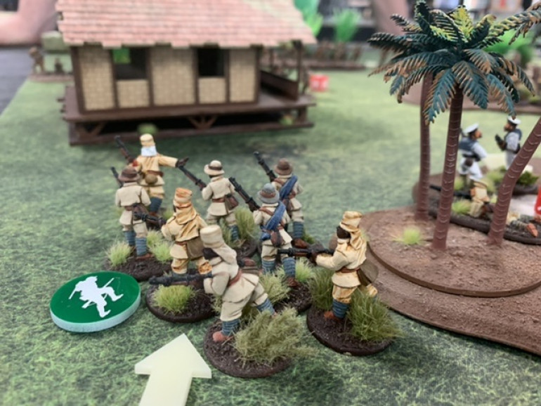 An Askari squad runs towards the building while the Naval squad moves through the palm trees and lays down suppressive fire.