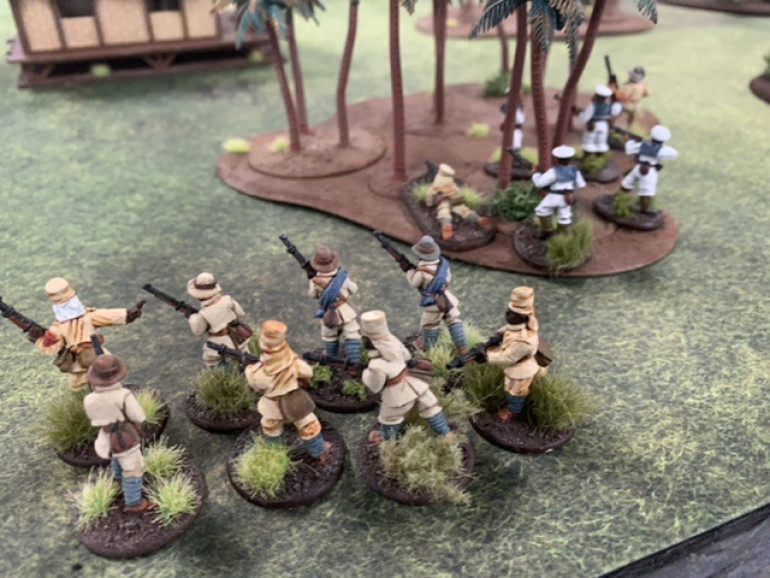 The German left flank uses the palm trees and the building as cover to maneuver closer to one of the objectives.
