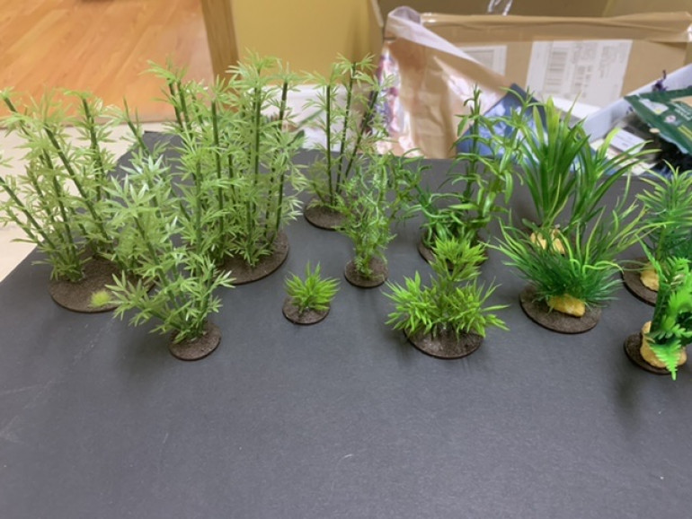 I then used a hot glue gun to glue down the various aquarium plants, cheap plastic bamboo and hobby craft plastic floral arrangements I could find. 