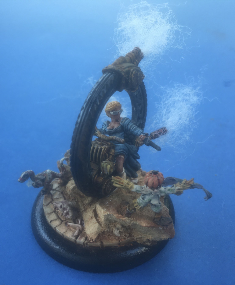 This is Lady Dorothy Quimby from Micro Art Studio’s Wolsung Ash and Oak crew on her steampunk mono-bike. She is accompanied by Citadel Miniatures’s Scarecrow Familiar and Bombshell Miniatures’s (60005) Sidekicks Tazjh Raptor Hatchling all mounted on a 50mm Micro Art Studio Troglodyte Lipped base.