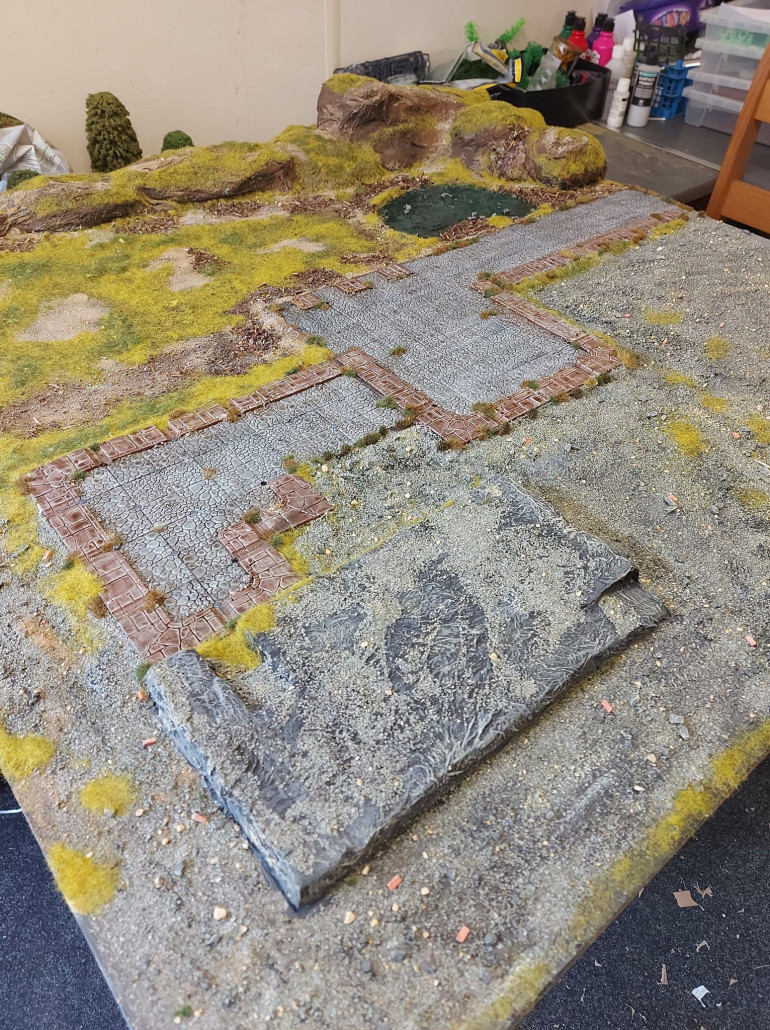 Got to do some fine detail work, now that the ground cover is all dry and done. After shaking off any loose flock, it was time to add some tufts around the paths and cobbles. Again, I used 3 different colours, to give it more texture and a more natural appearance. 