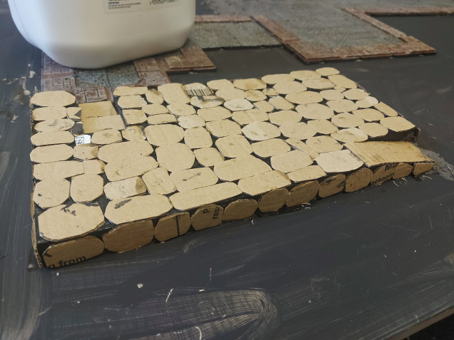 Today began with cutting out a million little cardboard stones to clad the tower base with. 